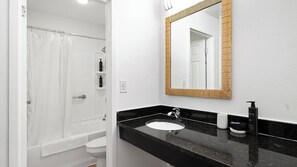 A bathroom with a bathtub, toilet, and sink. - Landing | Stunning 1BD, Clubhouse, Gym (Kissimmee)
