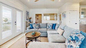 A living room with a sectional sofa, a round coffee table, and a ceiling fan. - New dog-friendly home with a private pool near the Gulf (Gulf Shores)