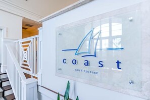 A sign with the word 'coast' and 'Gulf Cuisine' indicating a restaurant or dining area. - Two-story home with WiFi, partial ocean views, covered deck, dock, and W&D (Fort Morgan)