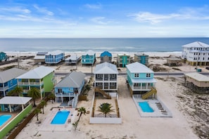 A beachfront hotel with multiple buildings, a swimming pool, and a beach view. - Gorgeous Oceanside Home with WiFi, Private Pool, Central AC, W&D - Steps From Beach (Gulf Shores)
