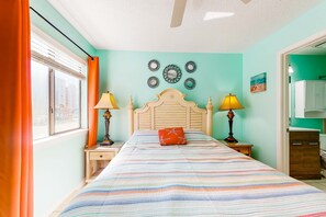 A bedroom with a bed, two bedside tables, a ceiling fan, and a window with curtains. - Home w/partial ocean views, internet, washer/dryer, central AC (Gulf Shores)