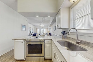 A modern kitchen with a built-in oven, a sink, and a refrigerator. - Large, Gulf front rental on the beach near Gulf Shores restaurants & activities (Gulf Shores)