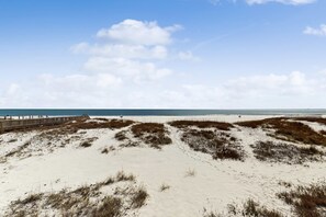 A sandy beach with a wooden boardwalk leading to the water. - Large, Gulf front rental on the beach near Gulf Shores restaurants & activities (Gulf Shores)
