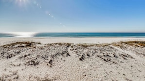 Ein Strand mit Dünen und blauem Himmel.