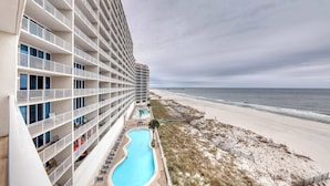 Un hotel con varios balcones, piscina y vistas a la playa.
