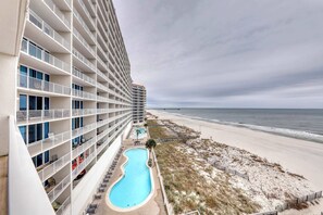 A hotel with multiple balconies, a swimming pool, and a beach view. - Gulf-front condo w private balcony & shared pools, hot tubs & gym (Gulf Shores)