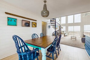 En matplats med ett träbord och blå stolar, vita väggar och en kristallkrona.