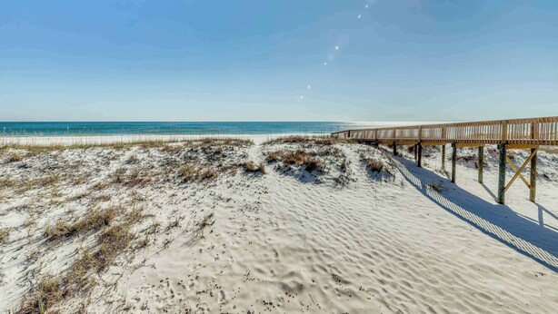 A sandy beach with a wooden boardwalk leading to the water. - Centrally-located Gulf front paradise wfurnished sun deck & gorgeous water view (Gulf Shores)