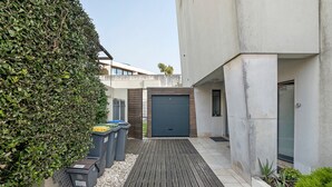A modern building with a grey facade, a wooden deck, and a neatly trimmed hedge. - Annex Bedroom – Oporto Garden (Porto)