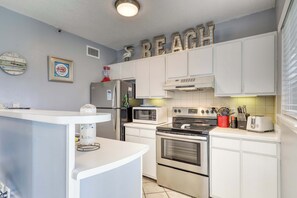 A kitchen with white cabinets, a microwave, an oven, and a refrigerator. - Spacious and inviting seaside condo with shared pools, sauna (Fort Morgan)