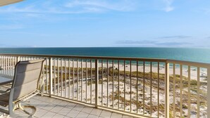 A balcony with a view of the beach and ocean. - Beautiful Home Steps From the Bay with Shared Pool & Hot Tub & Free WiFi, Balcony (Fort Morgan)