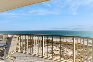 A balcony with a view of the beach and ocean. - Beautiful Home Steps From the Bay with Shared Pool & Hot Tub & Free WiFi, Balcony (Fort Morgan)