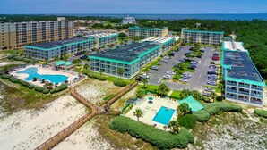 Resort com vários edifícios, piscina e área de praia.