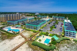 Un complexe hôtelier comprenant plusieurs bâtiments, une piscine et une plage.