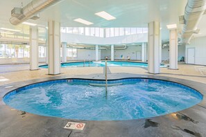 Une piscine intérieure à l’eau claire, avec une indication de la profondeur (90 cm) et un panneau interdisant de plonger.