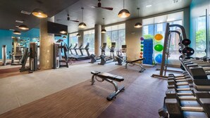 Una palestra con tapis roulant, macchinari per pesi e palle da ginnastica.