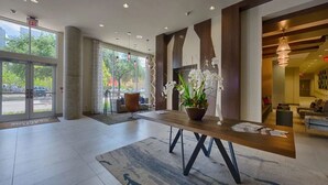 Un'ampia hall con reception, un'orchidea in vaso e vista sull'esterno.