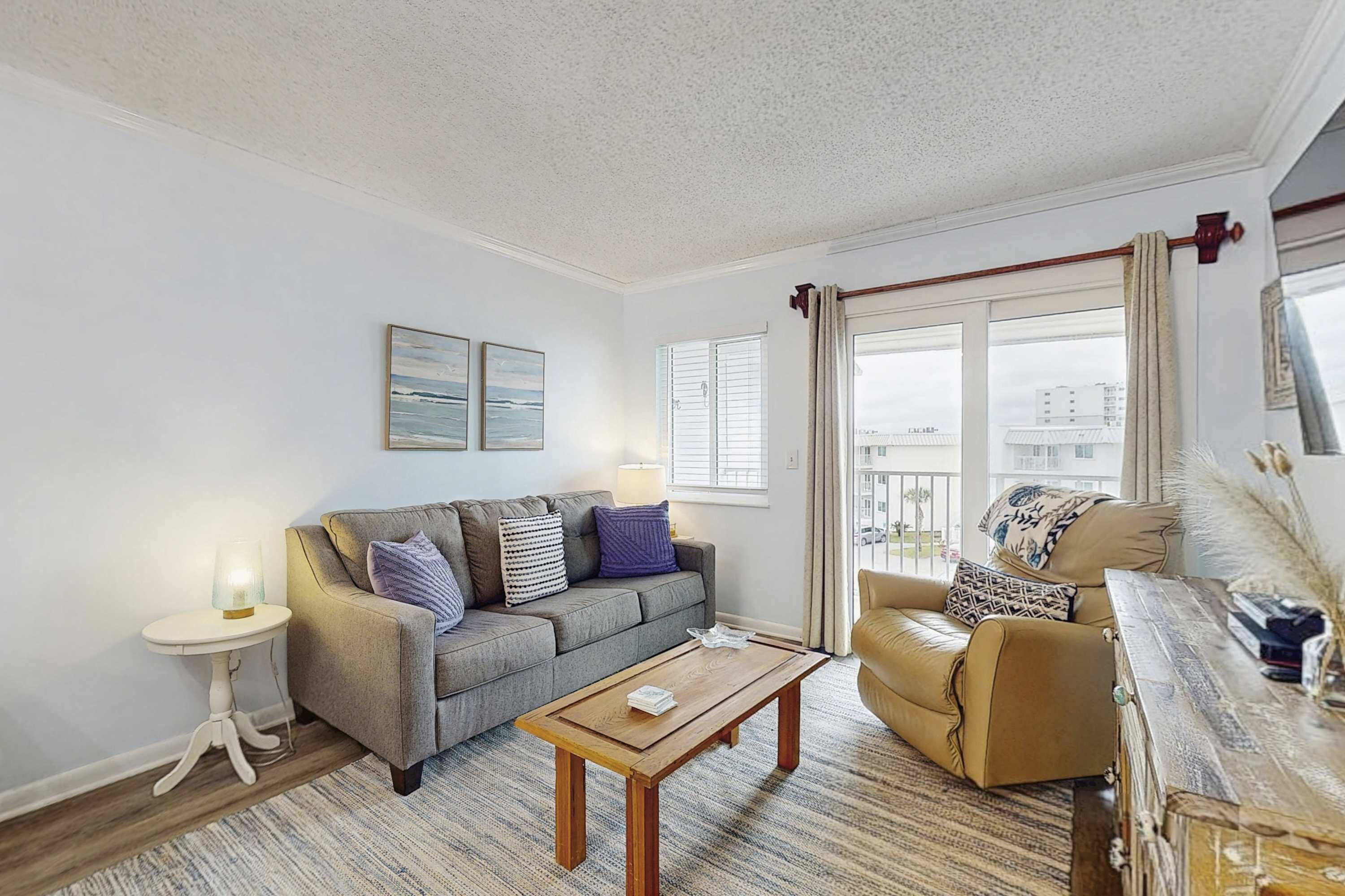 A living room with a sofa, armchair, coffee table, and a small side table.