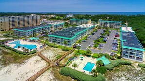 Ein Resort mit mehreren Gebäuden, einem Pool und einem Strandabschnitt.