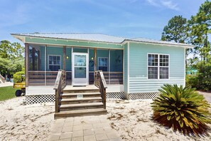 A small, light blue building with a covered porch and wooden steps leading to the entrance. - Gorgeous cottage with great amenties (Fort Morgan)