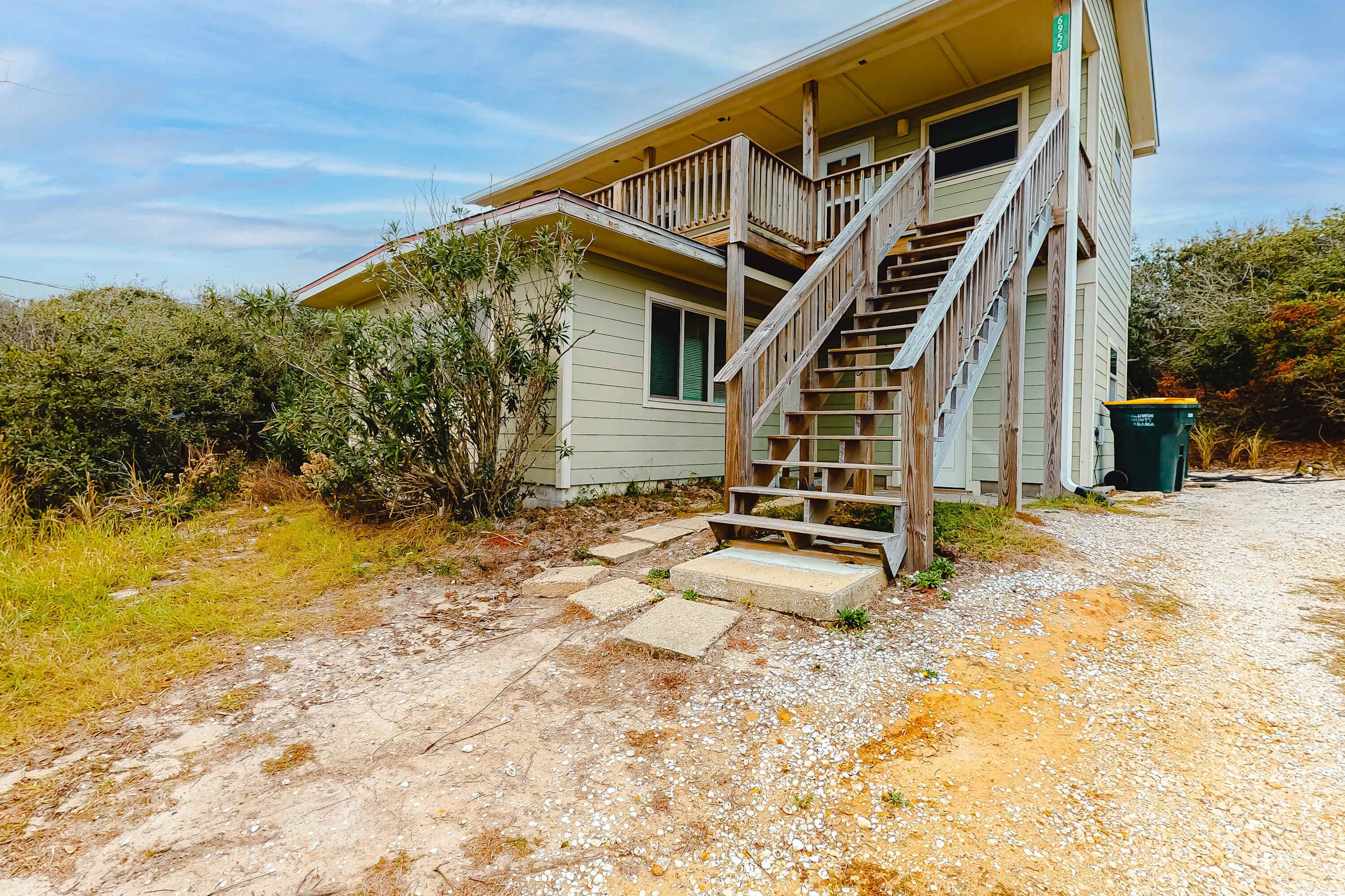 A house with a wooden staircase leading to a porch.