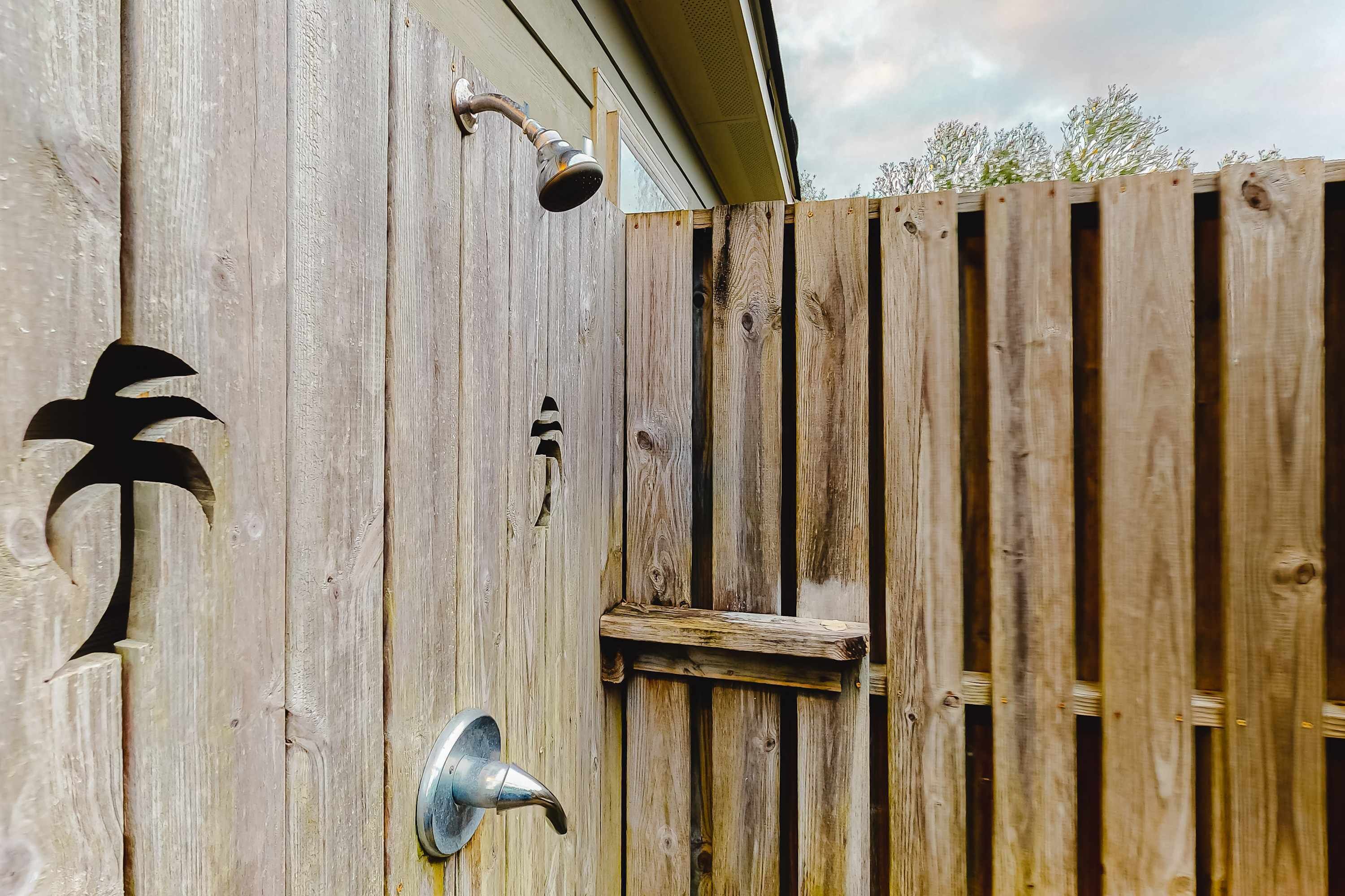 A wooden fence with a metal door handle and a metal door knocker.