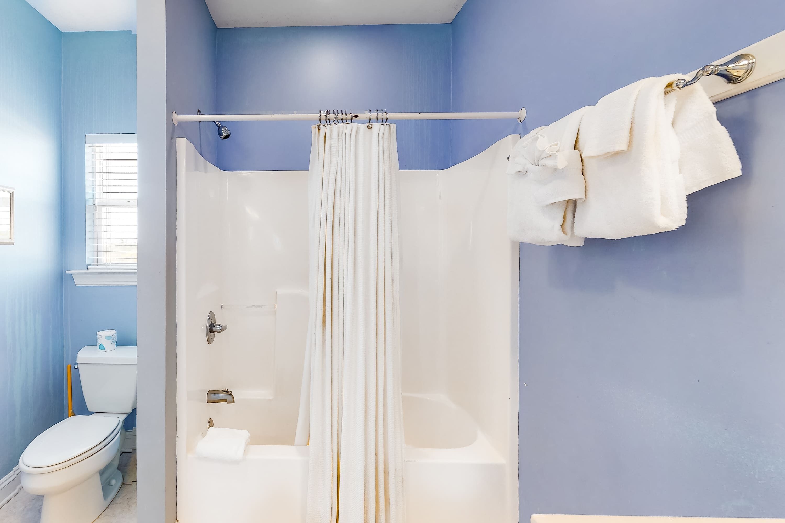 Ein Badezimmer mit Dusche, Toilette und Badewanne.