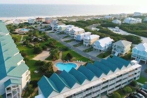 A coastal hotel with multiple-story buildings, a swimming pool, and a beach view. - Gulf view home with two-level deck, beach access & shared pools, hot tub, gym (Fort Morgan)