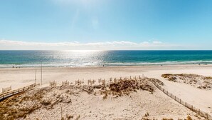 En strand med klart skint og sandet område, samt et hegn.