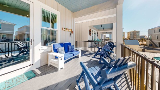 A covered outdoor area with a blue sofa, white coffee table, and blue lounge chairs. - Coastal dog-friendly gem near beach & town with pool, balcony, & central AC (Gulf Shores)