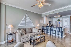 Un salon avec un canapé, une table basse et un ventilateur de plafond.