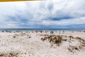 A beach with sand dunes, umbrellas, and people. - Beachfront home on the dunes w/ amazing Gulf views & shared pool (Gulf Shores)