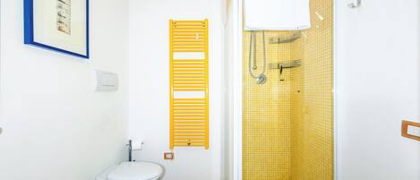 Un baño pequeño con inodoro, lavabo y ducha.
