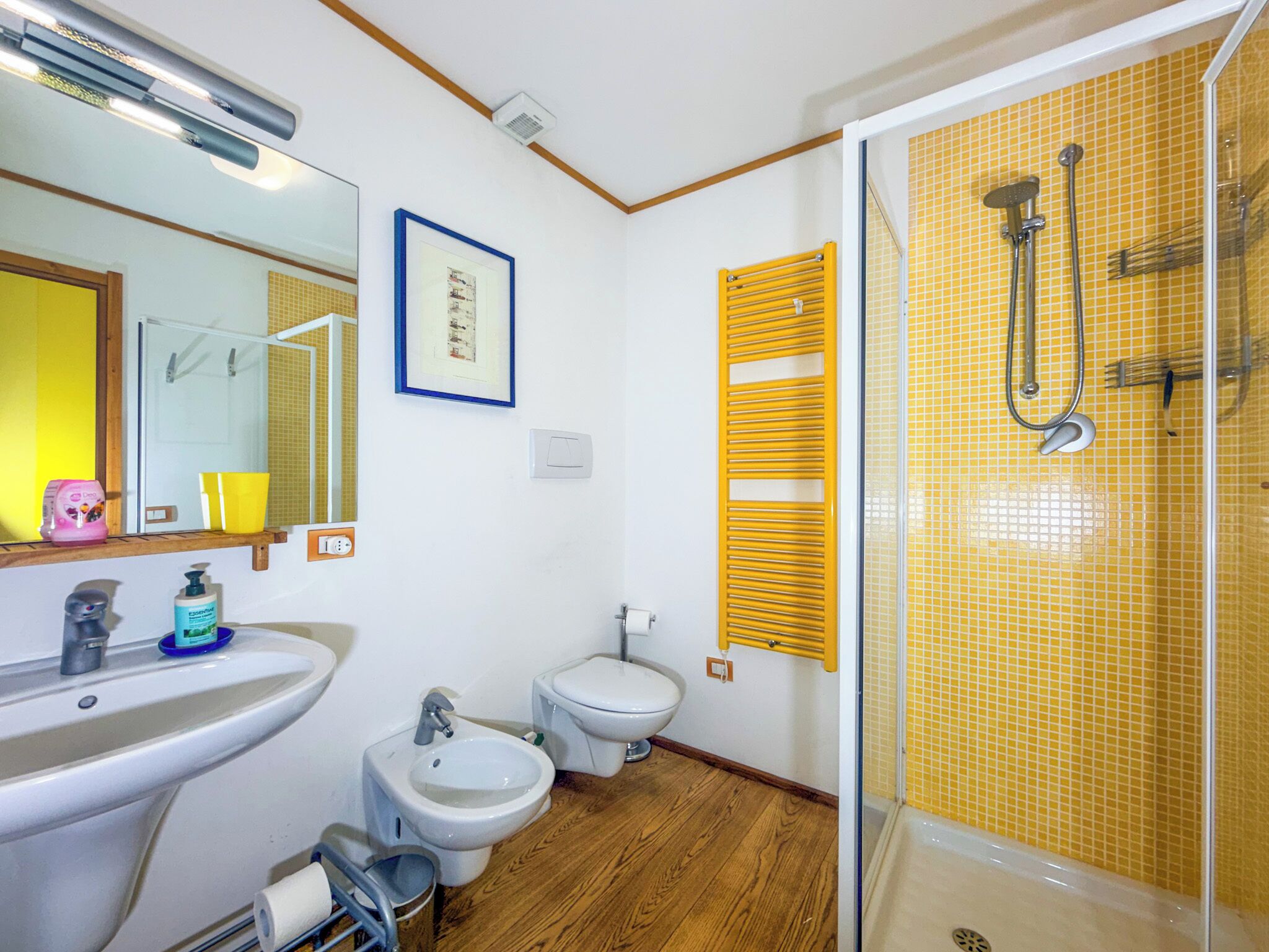 Un baño con lavamanos, bidé, inodoro y ducha.