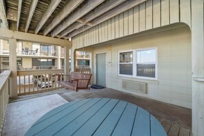 A wooden deck with a swing, a window, and a door. - Ocean-view condo with pool access, outdoor seating, central AC & WiFi (Gulf Shores)