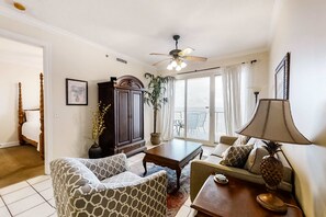 Ein Wohnzimmer mit Deckenventilator, einer Couch, einem Couchtisch und einer Lampe.