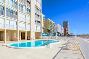 Un hôtel doté d’une piscine, de plusieurs balcons et offrant une vue sur la plage.