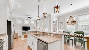 A modern kitchen with granite countertops, stainless steel appliances, and pendant lighting. - 2-Story Beach House w/Balcony, Washer/Dryer, Shared Pool, Snowbird-Friendly (Gulf Shores)