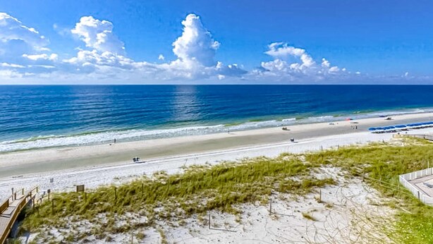 A beach with clear skies, a sandy shore, and a view of the ocean. - Recently renovated 5th-floor oceanfront condo with pool, ocean view & WiFi (Gulf Shores)