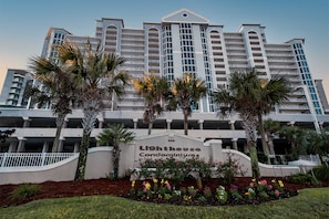 A multi-story hotel with a prominent sign reading 'Lighthouse Condominiums.' - Gulf-Front Condo w Gorgeous Views, Balcony & Shared Pools, Hot Tubs & Gym (Gulf Shores)