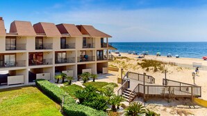 Un hôtel situé en bord de mer, doté de nombreux balcons, d’une plage de sable et offrant une vue dégagée sur l’océan.
