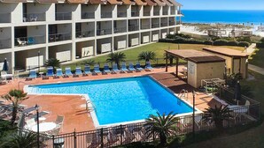 Un hôtel doté d’une piscine, de plusieurs balcons et offrant une vue sur la plage.
