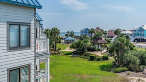 Un quartiere residenziale con una casa dotata di balcone, piscina e gazebo.