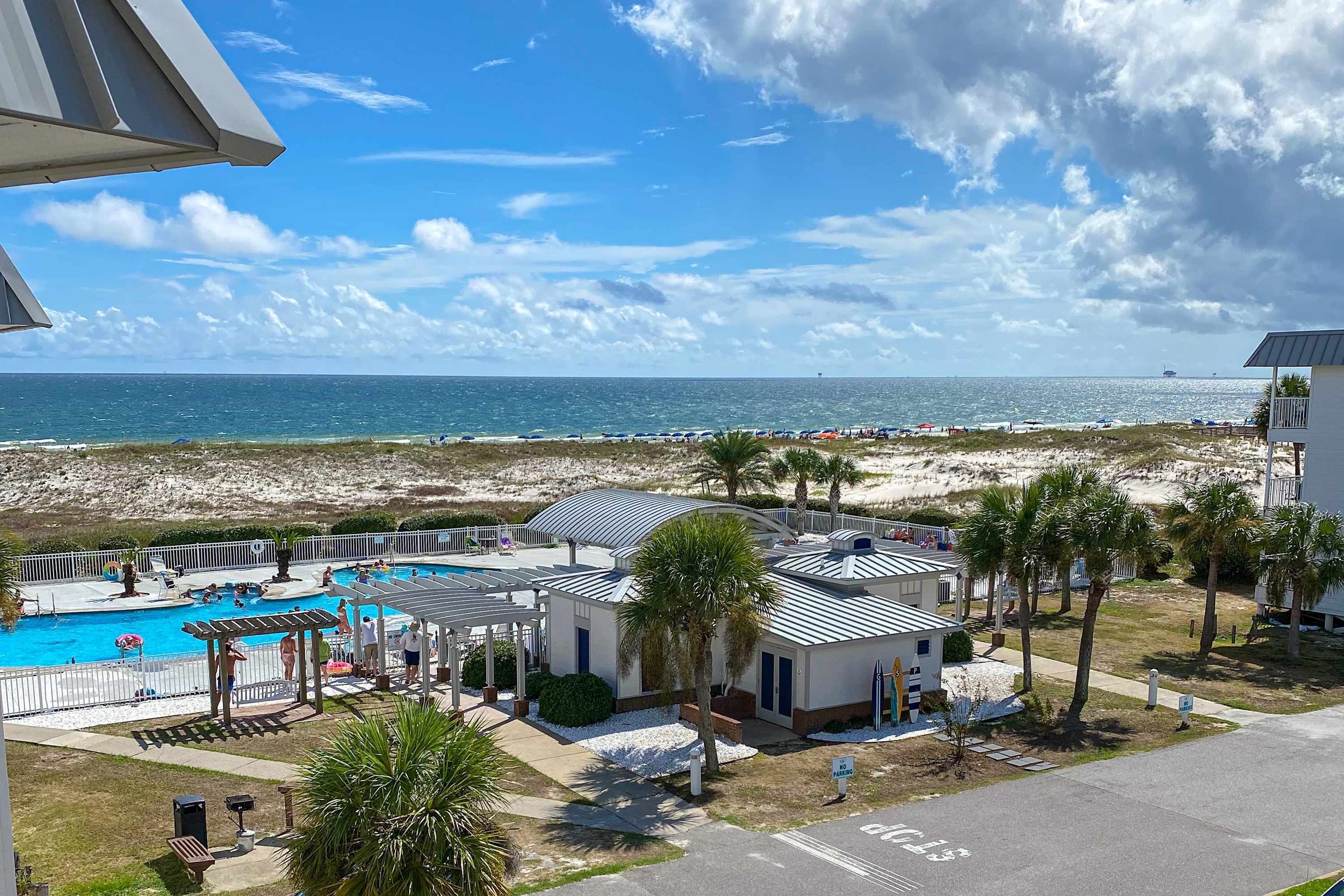 A beachside hotel with a swimming pool, beach access, and a view of the ocean.