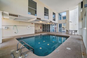 An indoor swimming pool with a clear view of the pool area, a lifebuoy, and a 911 emergency phone. - Unique dog-friendly Gulf-front condo with amazing views, pools, sauna, gym, & AC (Gulf Shores)