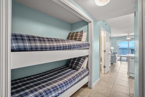 Een kamer met stapelbedden, een balkon en uitzicht op zee.