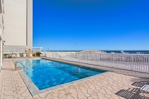 A swimming pool with a clear view of the ocean and a flagpole in the background. - Unique dog-friendly Gulf-front condo with amazing views, pools, sauna, gym, & AC (Gulf Shores)