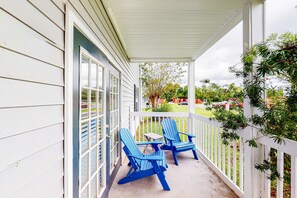 A porch with two blue Adirondack chairs and a small table. - Delightful coastal gem with pool, hot tub, private balcony, fast WiFi & AC (Gulf Shores)
