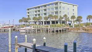 Un hôtel situé au bord de l’eau, doté de nombreux balcons, d’un quai et, en arrière-plan, d’une marina.
