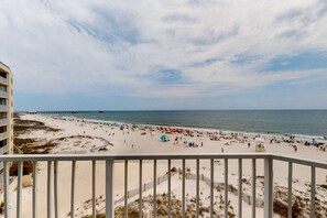 A beach with a wooden fence, a pier in the distance, and a clear sky. - Gulf-view condo with direct beach access, indoor & outdoor pools, hot tub, sauna (Gulf Shores)